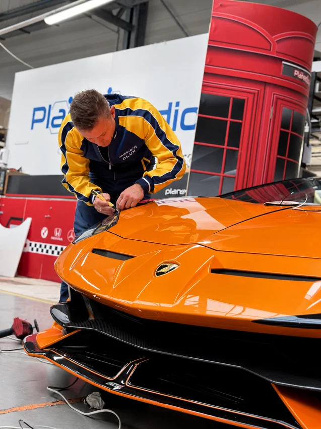 Praca przy krawędzi reflektora pomarańczowego Lamborghini.
