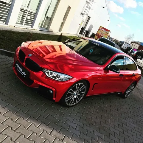 Czerwone wykończenie nadwozia BMW w świetle dziennym.